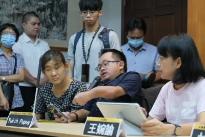 正在舉行記者會，座位最右方為立法委員王婉諭、中間為一位肢體障礙者正拿著麥克風發言、左方為一位視覺障礙者，兩位皆是台北市新活力自力生活協會成員，我站在後方。